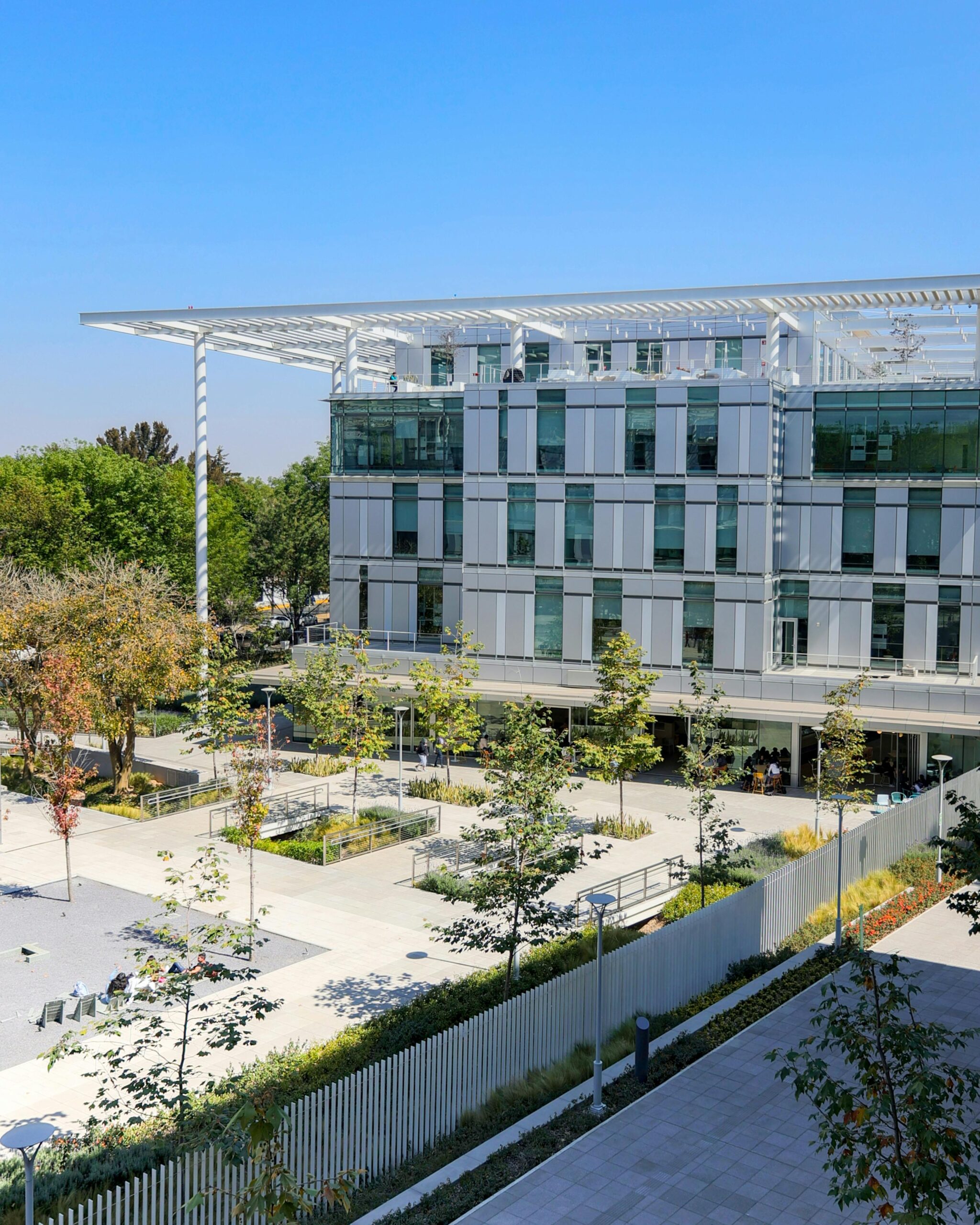 Contemporary architecture of a university building surrounded by trees.